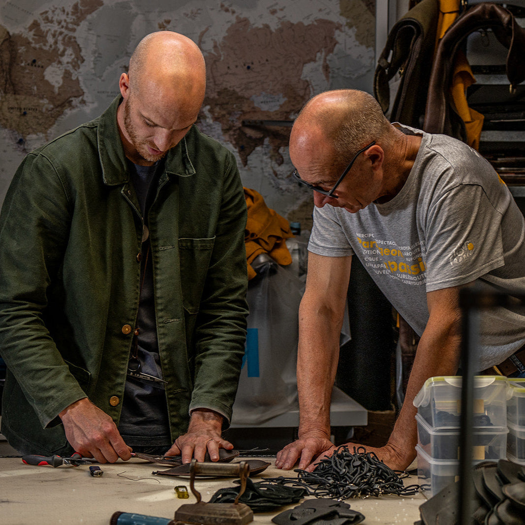 Two men working together in a workshop setting.
